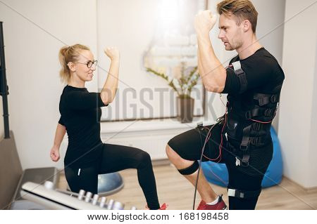 Young Sportsman Doing Ems Training With Personal Trainer