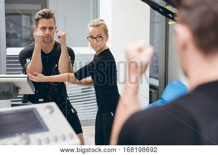 Sportsman Teached By Personal Trainer In Front Of Mirror