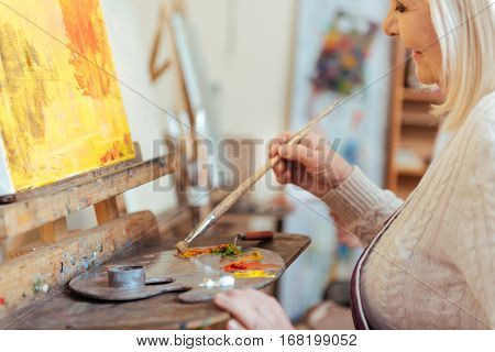 Art is my life. Female happy concentrated artist painting a picture while spending time in painting class and working.
