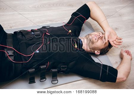 Tired Sportsman Lying On Floor After Training With Ems