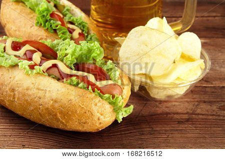 Hot Dogs With Glass Of Beer With Crisps On Wooden Board