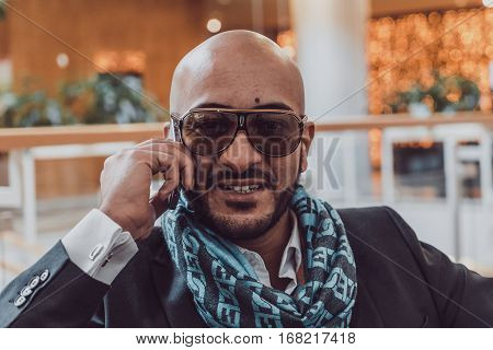 Arab businessman talking on mobile phone at a shopping center