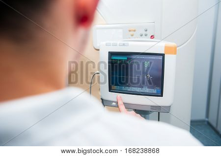 Close Up Doctor Adjusts Electrocardiograph In Computed Tomography Room. Selective Focus