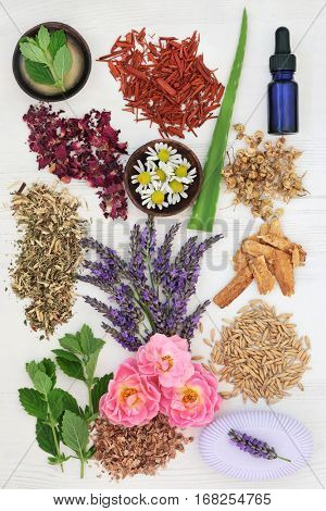 Herbal skincare healing ingredients to soothe psoriasis and eczema on distressed white wood background.