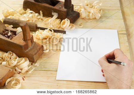 White sheet on wooden table for carpenter tools with sawdust. Copy space. Top view.