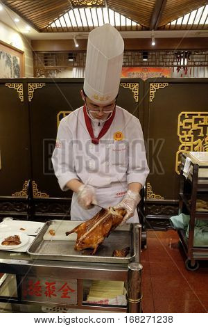 BEIJING - FEBRUARY 22: Cutting peking duck on a plate in the original Quanjude restaurant at the Qianmen street in Beijing, China, February 22, 2016.