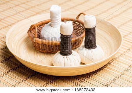 Massage bundles on a plate on bamboo mat. Spa, health, treatment, concept.