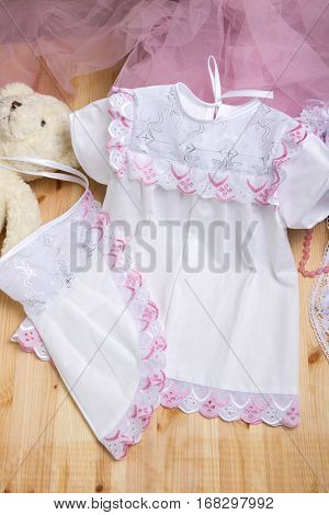 Christening dress. Set of christening clothes on wooden background