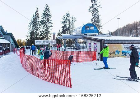 SLOVAKIA, STRBSKE PLESO - JANUARY 06, 2015: Skiers and other active people in Strbske Pleso. The village is a favorite ski tourist and health resort in the slovakian part of High Tatras mountains.