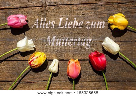 Tulips On Wooden Background And German Text For Mother´s Day