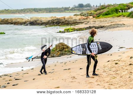 Middleton Australia - August 14 2016: Surfers with surfing boards getting out of water at Middleton Beach on a day. Middleton is one of the most famous places for surfing in South Australia