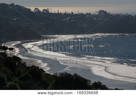 LaJolla Shores Beach, California viewed from hillside, white foamy waves and silhouetted land