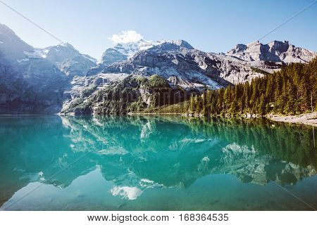 Panorama of the azure pond Oeschinensee. Popular tourist attraction. Picturesque and gorgeous scene. Location Swiss alps, Kandersteg, Bernese Oberland, Europe. Instagram toning effect. Beauty world.