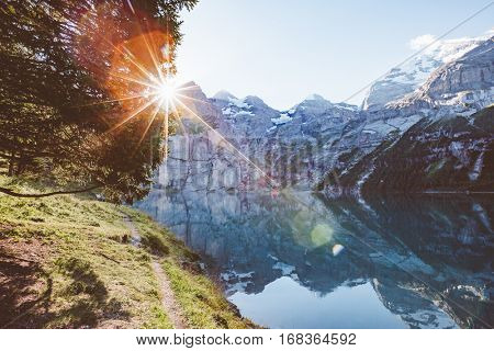 Glacier pond Oeschinensee. Popular tourist attraction. Picturesque and gorgeous scene. Location Swiss alps, Kandersteg, Bernese Oberland, Europe. Vintage effect. Instagram filtered. Beauty world.