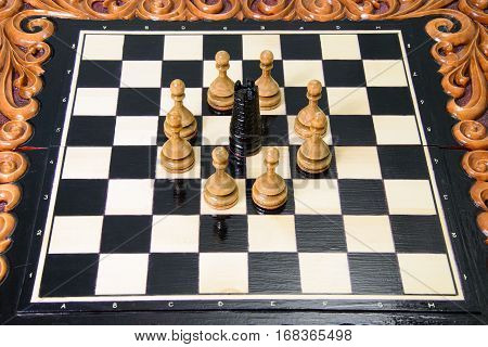 The chess pieces are placed on the chessboard. Defeated black king. The player admitted defeat