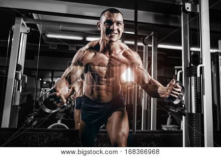 Athlete muscular bodybuilder training on simulator in the gym. Chest training in gym