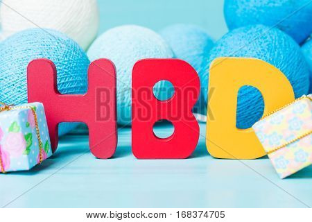 Colorful happy birthday words with garland on blue wooden background