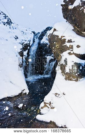Small waterfall during heavy snow at blue hour, mountain Kozomor, Serbia