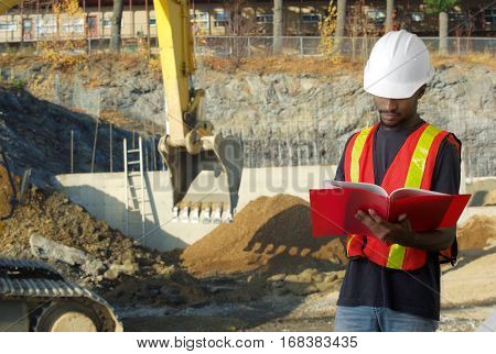construction worker holding document on excavator site