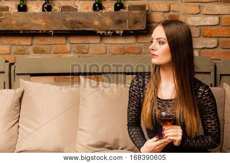 Woman Tasting Wine In Rural Cottage Interior