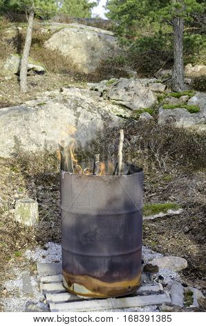 Fire in one old rusty barell standing in the nature