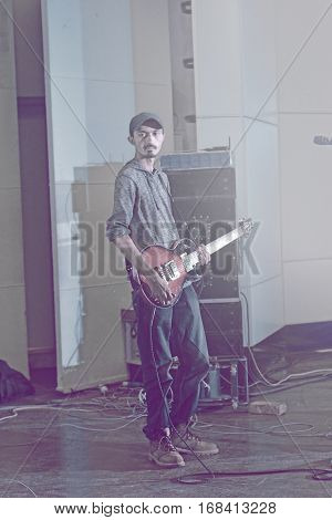 Guitarist holding electric guitar performing live on stage