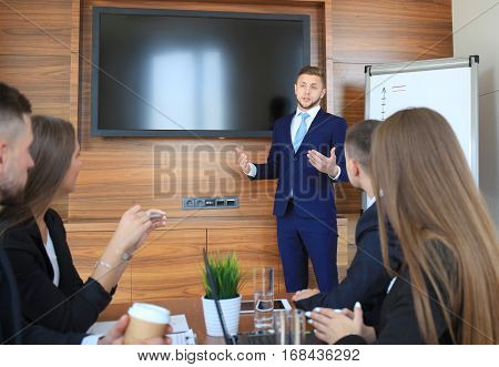 Business training at office businessman presenting successful financial numbers on screen of plasma TV at meeting room
