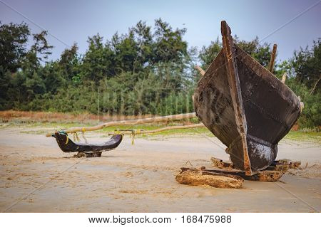 Traditional fishing boat on palm trees background Cavelossim Beach in South Goa, India