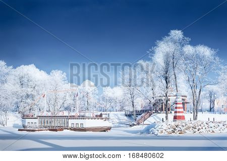 Navigation Lighthouse frozen water will shore frosted trees rime snow stone jetty pier tourist ship sunny day
