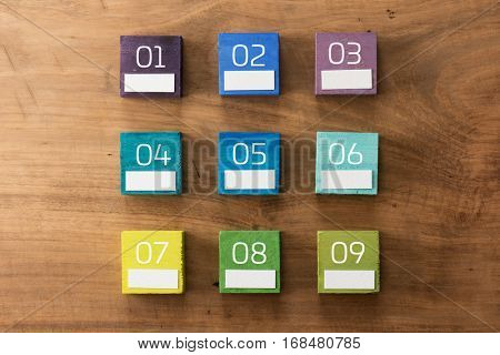 Index, menu or cover abstract back ground, with number and blank white space for custom text, consisting of nine hand painted colored wooden cubes on grungy wooden background with vintage taste.  