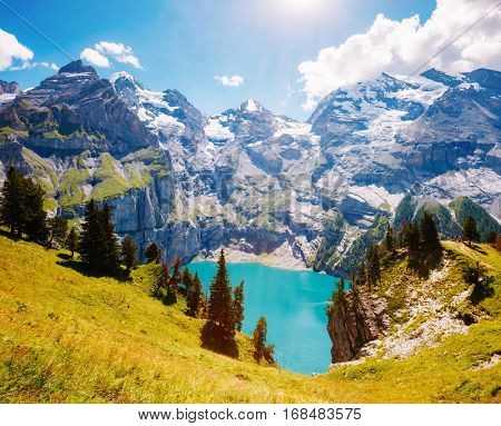 Panorama of the azure pond Oeschinensee. Popular tourist attraction. Picturesque and gorgeous scene. Location Swiss alps, Kandersteg, Bernese Oberland, Europe. Instagram toning effect. Beauty world.