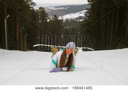 Smiling girl with snowboard in the ski resort