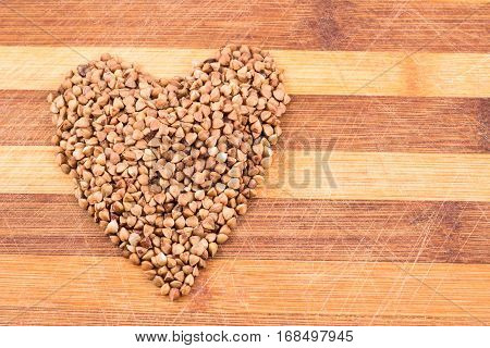 Heartt from buckwheat on a wooden background is a very useful cereal