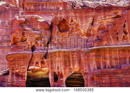 Rose Red Rock Tomb Street of Facades Petra Jordan. Built by the Nabataens in 200 BC to 400 AD. Rose Red canyon walls create many abstracts close up. Inside the Tombs the rose red can become blood red. Reds are created by magnesium in sandstone.
