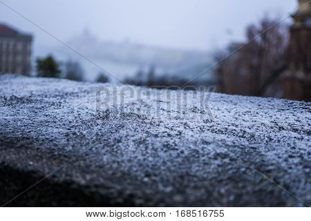 A shallow focus highlights frost on top of a stone wall