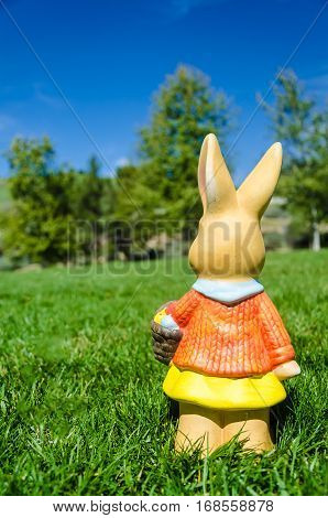 Easter bunny waith basket and color eggs in field - American landscape