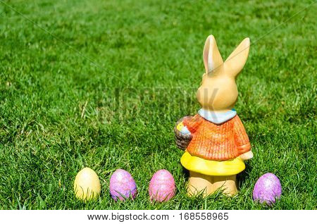 Easter bunny waith basket and color eggs in field - American landscape