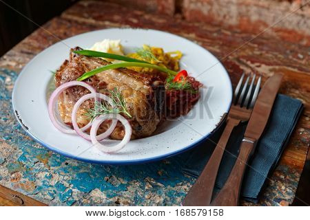 Grilled pork ribs with sauerkraut and mashed potatoes on old grunge peeled painted table