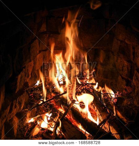 Burning fire in the brick fireplace. Comfort.