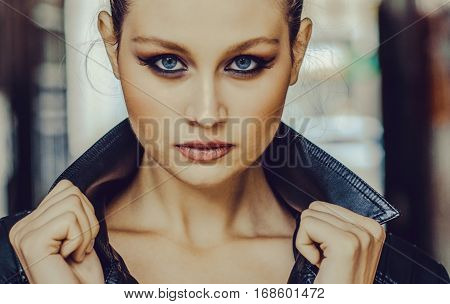 Beautiful girl with blue eyes close up on blurred background
