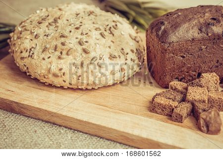 Crackers, rye bread and bread with sunflower seeds on a board closeup