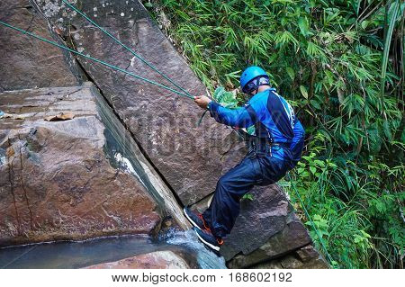 Beaufort,Sabah,Malaysia-Jan 28,2017:Adventure man rappelling Jempangah waterfall in Beaufort,Sabah,Borneo.Waterfall Abseiling activity adventure getting famous in Sabah,Borneo,Malaysia