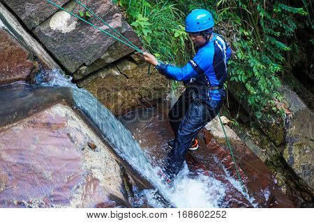 Beaufort,Sabah,Malaysia-Jan 28,2017:Adventure man rappelling Jempangah waterfall in Beaufort,Sabah,Borneo.Waterfall Abseiling activity adventure getting famous in Sabah,Borneo,Malaysia