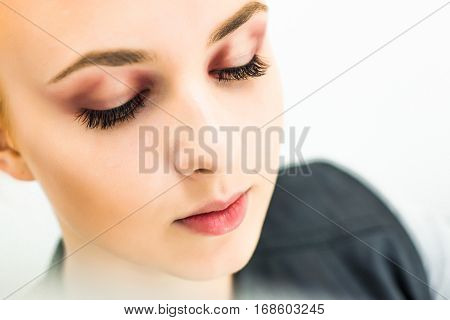 Woman with natural make-up eyes and lips on a light background. Close-up