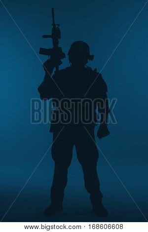 United states Marine Corps special operations command Marsoc raider with weapon. Silhouette of of Marine Special Operator blue background full body