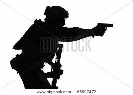 United states Marine Corps special operations command Marsoc raider with weapon aiming pistol. Silhouette of Marine Special Operator white background