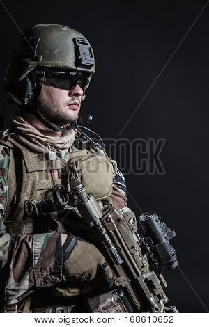 United states Marine Corps special operations command Marsoc raider with weapon. Studio shot of Marine Special Operator half-turning black background