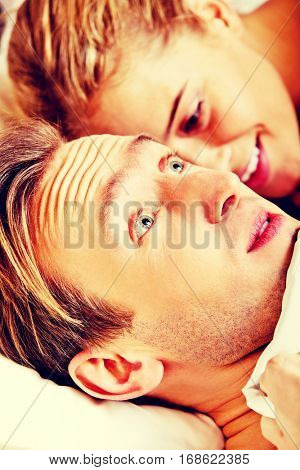 Woman whispering to her husband and he laughting