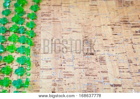 Green shamrock decorations over cork board for St. Patrick's Day with room for copy