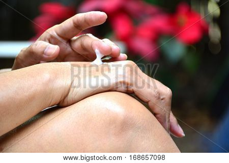 hand of woman apply lotion on skin of back hand
